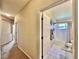 Hallway leading to a bright bathroom with white tile and natural light at 2707 Barnsley Ln, Kissimmee, FL 34744