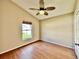 An empty bedroom with hardwood floors, a ceiling fan, and a window at 2707 Barnsley Ln, Kissimmee, FL 34744