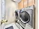 Bright laundry room featuring modern washer and dryer units, and white tile flooring at 2707 Barnsley Ln, Kissimmee, FL 34744