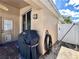 View of the patio featuring a Weber grill and hose rack, along with a door and gate for easy access at 2707 Barnsley Ln, Kissimmee, FL 34744