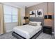 Bedroom with natural light, carpet, and neutral decor featuring a gray headboard and matching end tables at 288 Auburn Ave, Kissimmee, FL 34747