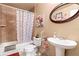 Bathroom with a tub, shower, toilet, patterned curtain, vanity, round mirror, and neutral colored walls at 288 Garland, Deltona, FL 32725