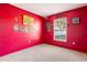 A bedroom with bright red walls, a superhero theme, and a window at 288 Garland, Deltona, FL 32725