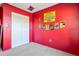 A bedroom with bright red walls, a superhero theme, and a closet at 288 Garland, Deltona, FL 32725