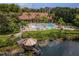 Aerial view of the clubhouse with a gazebo on the lake, pool, and palm trees at 3018 Red Ginger Rd, Kissimmee, FL 34747