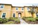 Inviting townhome featuring a well-manicured front yard and a bright, yellow exterior at 3018 Red Ginger Rd, Kissimmee, FL 34747