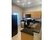 Well-lit kitchen featuring granite countertops and modern, black appliances at 3018 Red Ginger Rd, Kissimmee, FL 34747