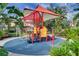 Colorful community playground equipment with a shade structure, surrounded by tropical landscaping at 3018 Red Ginger Rd, Kissimmee, FL 34747