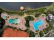 Aerial view of a community pool area with multiple pools, lounge chairs, and lush landscaping near a lake at 3018 Red Ginger Rd, Kissimmee, FL 34747