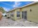 Exterior view of backyard with brick pavers, lush landscaping, and sliding glass door entry to the home at 3288 Brewster Dr, Kissimmee, FL 34743