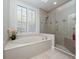 Bathroom with a soaking tub under a window and separate glass enclosed shower at 3369 Park Grove Ct, Longwood, FL 32779