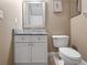 Cozy powder room features a vanity with marble top and a framed mirror; toilet is conveniently located nearby at 3369 Park Grove Ct, Longwood, FL 32779