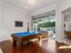 Bright game room with a pool table, chandelier, and sliding glass doors to an outdoor seating area at 3369 Park Grove Ct, Longwood, FL 32779