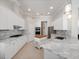 Modern kitchen with white cabinetry, marble countertops, stainless appliances, and tiled flooring offers a clean aesthetic at 3369 Park Grove Ct, Longwood, FL 32779