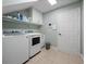 Bright laundry room with white washer, dryer, cabinets, and shelving for organized storage solutions at 3369 Park Grove Ct, Longwood, FL 32779