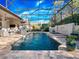 Refreshing screened-in pool area with a spa, charming water feature, and a beautifully landscaped patio with seating at 3369 Park Grove Ct, Longwood, FL 32779