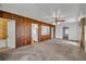 The living room features retro wood paneling, ceiling fan and carpeted floors at 390 Lake Geneva Rd, Geneva, FL 32732