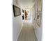 Bright hallway with white walls, wood flooring, framed artwork, and closet with shutter doors at 402 Cypress Dr # 402, Haines City, FL 33844