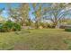 Large grassy backyard with mature trees, a wooden fence, and plenty of space for recreation and relaxation at 4029 Cool Water Ct, Winter Park, FL 32792