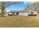 Charming single-story home featuring a blue front door, complemented by mature trees and a well-manicured lawn at 4029 Cool Water Ct, Winter Park, FL 32792