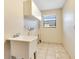 Functional laundry room features tile floors, sink, white cabinets and a window for natural light at 4029 Cool Water Ct, Winter Park, FL 32792