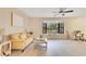 Sunlit living room featuring wood floors, large bay window, and stylish seating arrangement for relaxation and comfort at 4029 Cool Water Ct, Winter Park, FL 32792