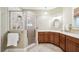 Bright bathroom showcasing a glass-enclosed shower and vanity with wood cabinetry at 428 Highland Ave, Orlando, FL 32801