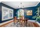 Elegant dining room boasting dark blue walls, hardwood floors, and a chandelier that offers a view into the kitchen at 428 Highland Ave, Orlando, FL 32801