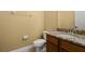 Bathroom featuring granite countertop, toilet, cabinet, mirror, and towel rack at 4414 Azure Isle Way, Kissimmee, FL 34744