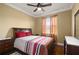 Bedroom featuring wood floors, ceiling fan, and a comfortable bed with colorful striped comforter at 4414 Azure Isle Way, Kissimmee, FL 34744