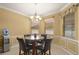 Bright breakfast nook with a marble table set, black chairs, water dispenser, and multiple windows at 4414 Azure Isle Way, Kissimmee, FL 34744