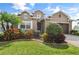 Beautiful two-story home featuring a manicured lawn and colorful landscaping at 4414 Azure Isle Way, Kissimmee, FL 34744