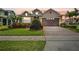 Charming two-story home featuring a manicured lawn and colorful landscaping at 4414 Azure Isle Way, Kissimmee, FL 34744