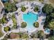 Aerial view of a landscaped community pool with a hot tub and seating with shade at 601 Orange Cosmos Blvd, Davenport, FL 33837