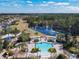 Aerial view of the community pool, surrounding landscaping, seating areas, and a serene lake at 601 Orange Cosmos Blvd, Davenport, FL 33837