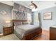 This primary bedroom features a canopy bed, ceiling fan, gray walls and wood floors at 601 Orange Cosmos Blvd, Davenport, FL 33837