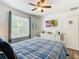 A coastal-style bedroom with a ceiling fan, a dresser, and a window allowing natural light at 601 Orange Cosmos Blvd, Davenport, FL 33837