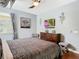 This bedroom features a ceiling fan, mounted TV, a dark wood dresser and modern decor at 601 Orange Cosmos Blvd, Davenport, FL 33837