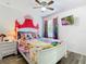 Disney themed bedroom featuring a canopy bed, ceiling fan, and tv at 601 Orange Cosmos Blvd, Davenport, FL 33837