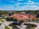 Beautiful clubhouse with a red tile roof, fountain, and lush landscaping under a partly cloudy sky at 601 Orange Cosmos Blvd, Davenport, FL 33837