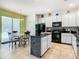 A kitchen featuring tile flooring, granite counters, white cabinets, and a black island and appliances at 601 Orange Cosmos Blvd, Davenport, FL 33837