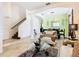 Bright and airy living room with neutral tones, a staircase, and a dining area at 601 Orange Cosmos Blvd, Davenport, FL 33837