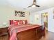 Main bedroom with a dark wood floor, a ceiling fan, and a picture hanging above the bed at 601 Orange Cosmos Blvd, Davenport, FL 33837