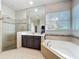 Luxurious bathroom featuring a glass-enclosed shower, soaking tub, and elegant tile work at 6244 Little Lake Sawyer Dr, Windermere, FL 34786