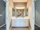 Bathroom featuring double sinks, decorative mirror, and cabinet storage at 6244 Little Lake Sawyer Dr, Windermere, FL 34786