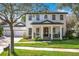 Charming two-story home with a black door, white columns, manicured lawn, and beautiful landscaping at 6244 Little Lake Sawyer Dr, Windermere, FL 34786