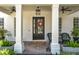 Inviting front porch with stylish decor, including potted plants and comfortable seating at 6244 Little Lake Sawyer Dr, Windermere, FL 34786