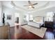 Serene main bedroom with a tray ceiling, wood floors, and an en-suite bathroom at 6244 Little Lake Sawyer Dr, Windermere, FL 34786