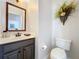 Well-appointed powder room with modern vanity, mirror, and decorative wall art at 6244 Little Lake Sawyer Dr, Windermere, FL 34786