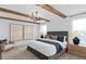 Serene main bedroom with wood beam ceiling, statement lighting, and a king-size bed with stylish decor at 7062 Rosy Sky Ave, Orlando, FL 32829